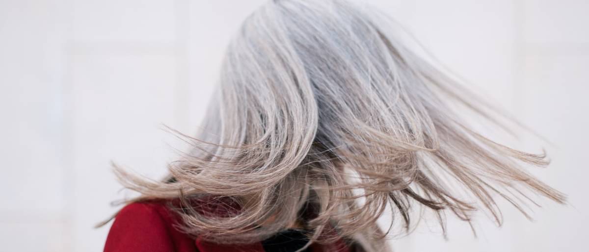Frau schüttelt ihre grauen Haare 