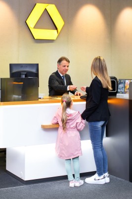 Female customer with child at a bank cash register