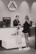 Female customer with child at a bank cash register b/w
