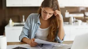 Junge Frau schaut konzentriert über einige Unterlagen.