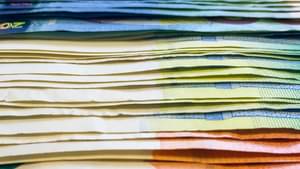 Nahaufnahme von gestapelten 10- und 20-Euro Scheinen.