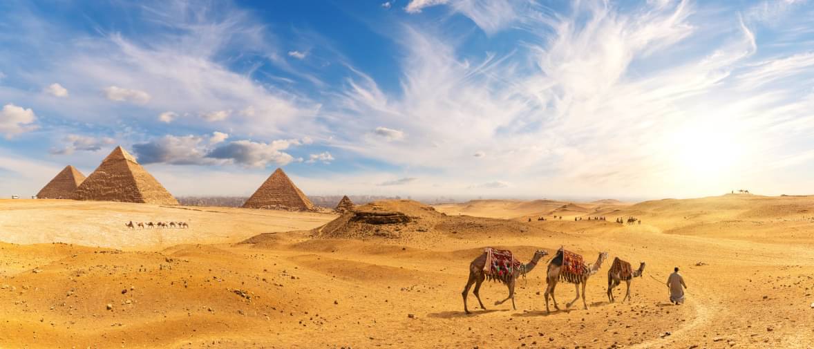 Ägyptens Pyramiden unter blauem Himmel, Kamele im Vordergrund, ein Reisetipp