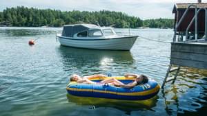 Kinder liegen im Schlauchboot auf einem See