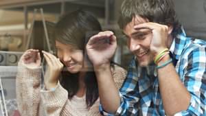 Eine Frau und ein Mann schauen durch eine Glasscheibe