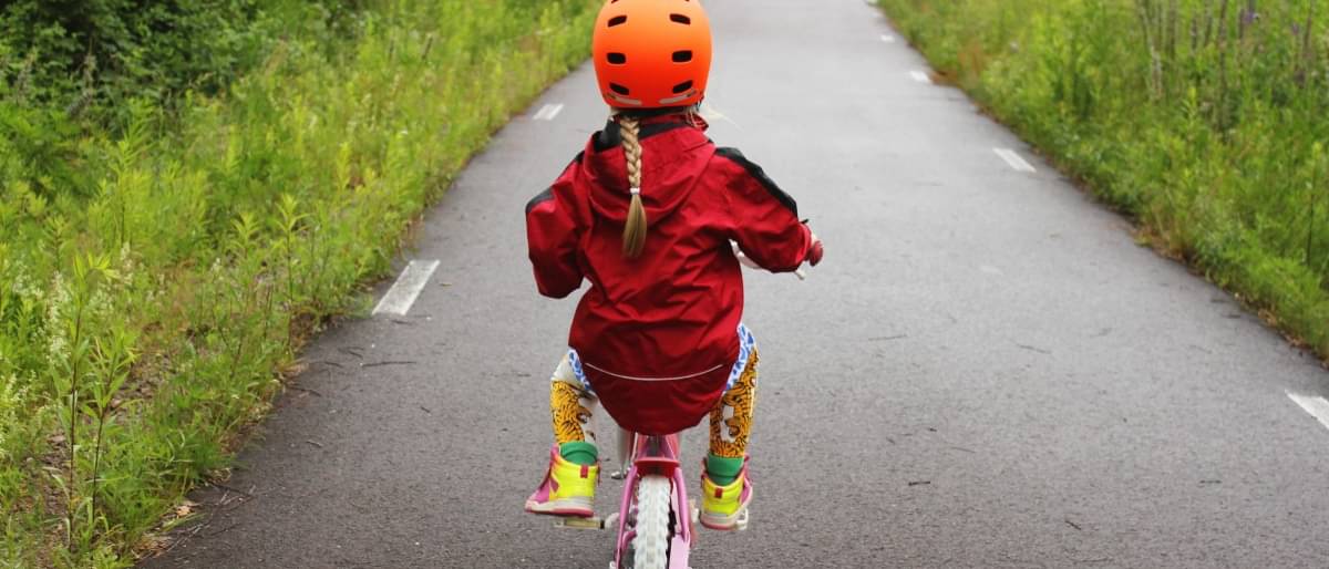 Kleines Mädchen fährt Fahrrad mit Stützrädern - Führerschein Kosten