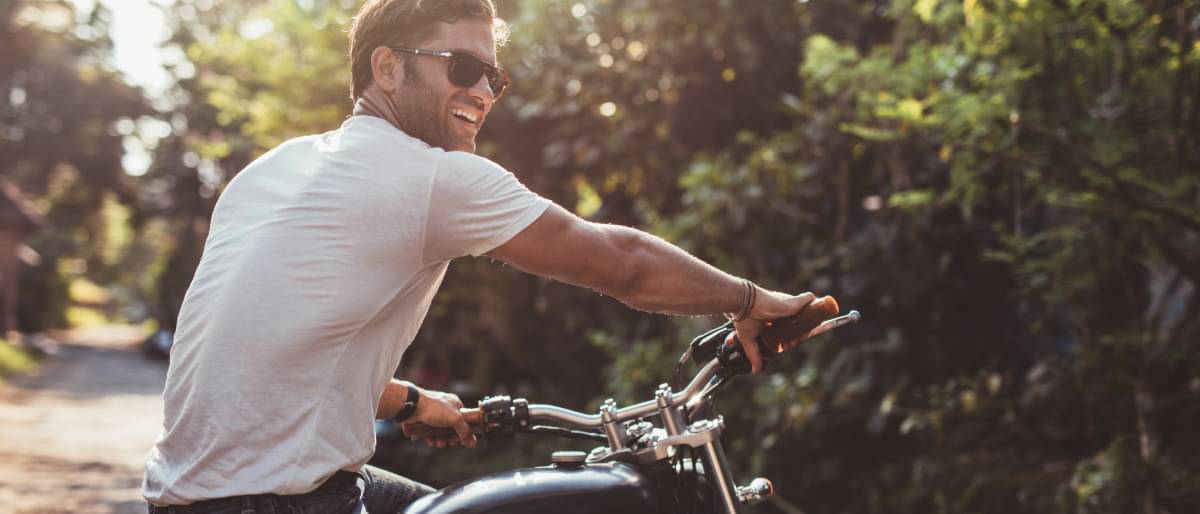 Mann auf Motorrad, hat gerade seinen Motorradführerschein gemacht - Motorradfuehrerschein Kosten