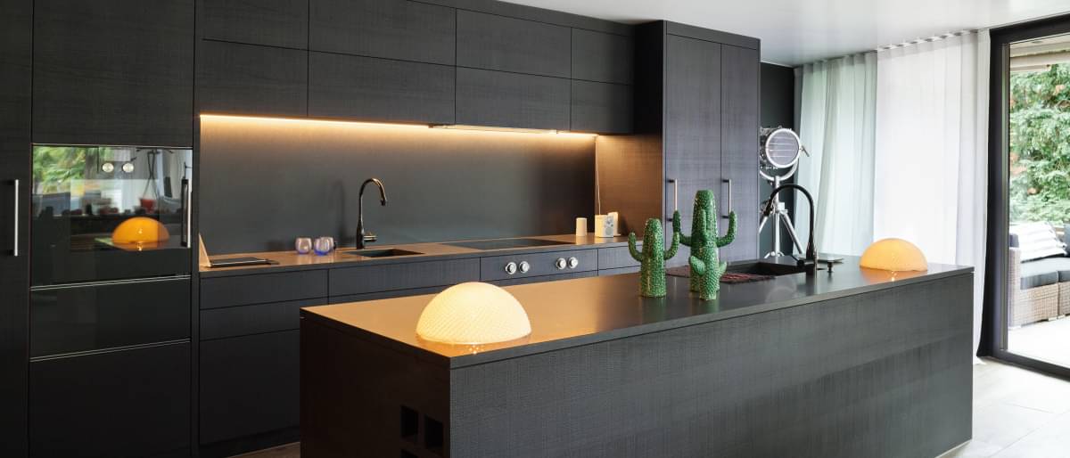 Moderne, elegante Einbauküche in Schwarz mit Leuchtelementen.