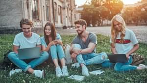 Gruppe von Studenten, die im Park sitzen und sich unterhalten