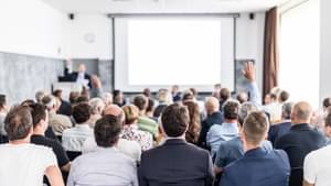 Einige Dutzend Mitglieder sitzen bei einem Vortrag einer Jahreshauptversammlung.