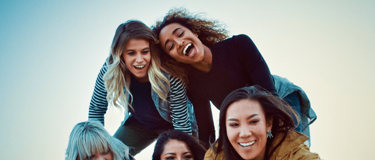 Fünf junge Frauen bilden eine Pyramide und lächeln für ein Selfie in die Kamera.