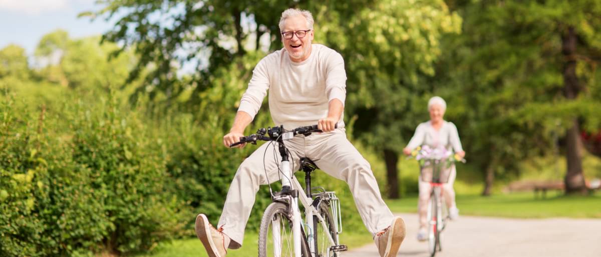 Mid-Ager fahren gut gelaunt Fahrrad durch die Natur