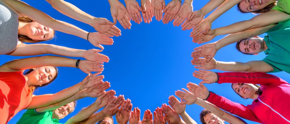 Mehrere Menschen formen mit ihren Händen einen Kreis. Dieses Bild steht für die Vielfalt in der Gesellschaft.  