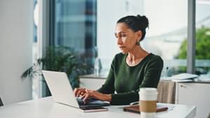 Eine konzentrierte Frau recherchiert am Laptop