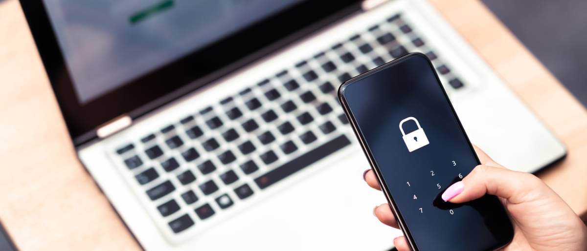 Cyber Sicherheit - Eine Person tippt ein Passwort in ein gesperrtes Handy ein