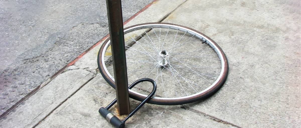 Fahrradreifen ohne Fahrrad an einem Pfosten angeschlossen. - Hausratversicherung