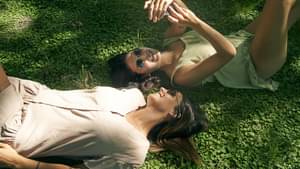 Frauen liegen auf dem Rasen und schauen in den Himmel 