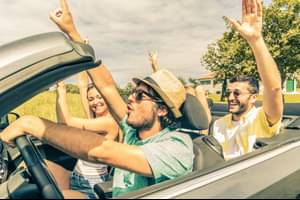 Junge, lachende Menschen in einem Cabriolet