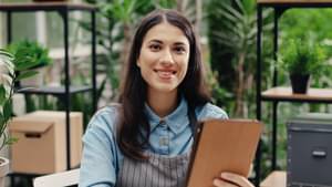 Gründerin in ihrem Geschäft mit Tablet in der Hand