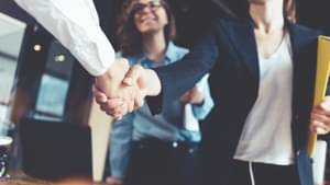 Handschütteln über einen Tisch hinweg