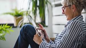 Eine Frau schauen erfreut auf ein Tablet