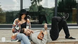 Pärchen sitzt auf einer Holzterrasse vor dessen Haus.