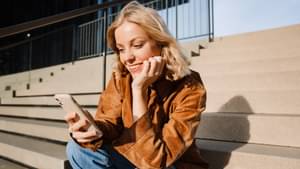 Junge Frau investiert am Smartphone