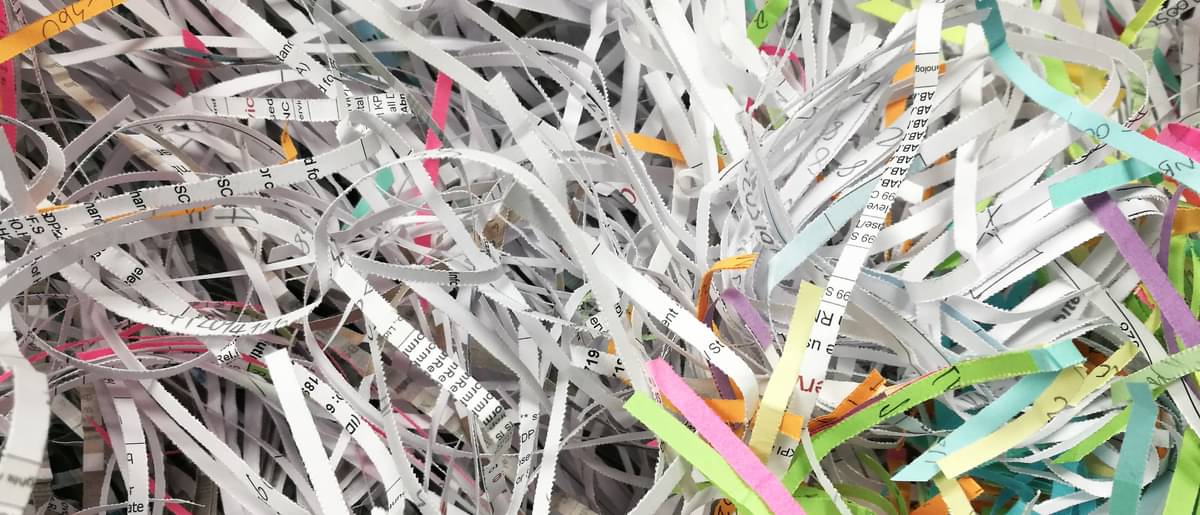 Geschreddertes buntes und weißes Papier - Schulden abbauen