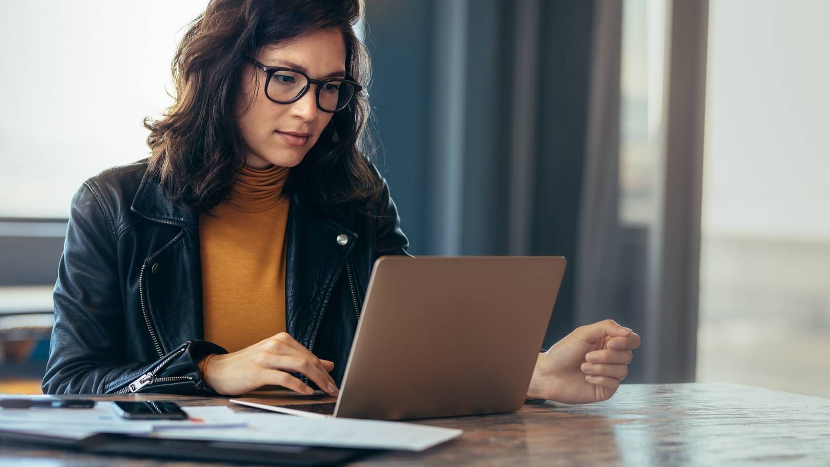 eine Frau arbeitet im Büro an ihrem Laptop