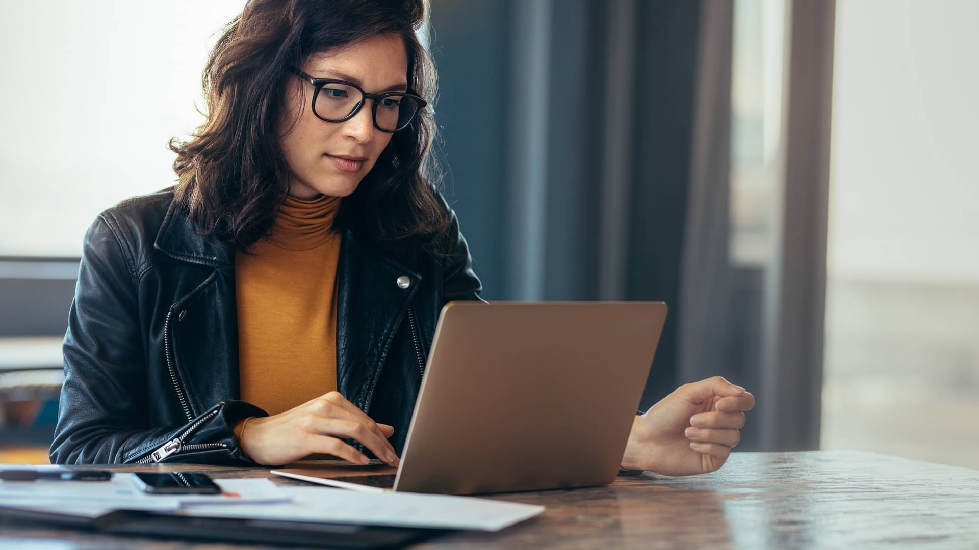 eine Frau arbeitet im Büro an ihrem Laptop