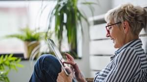 Eine Frau schauen erfreut auf ein Tablet